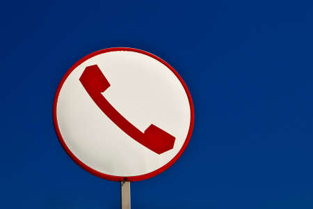 A phone sign over a blue sky.の写真素材
