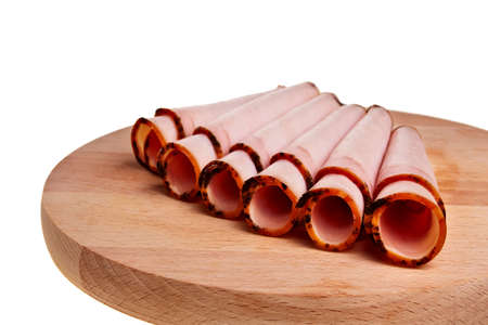 Smoked ham rolls on wooden desk over white background.の写真素材