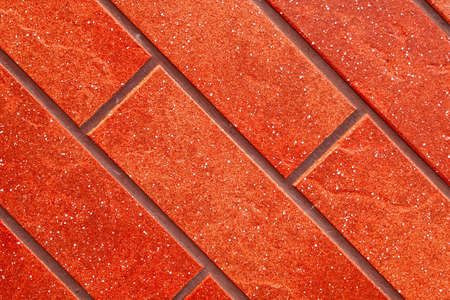 Dark red brick tile wall closeup view.