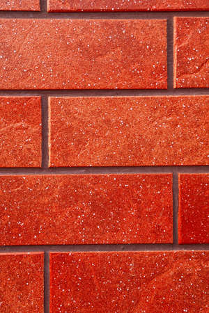 Dark red brick tile wall closeup view.の写真素材