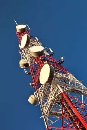 Telecommunication mast with microwave link antennas over a blue sky.の写真素材
