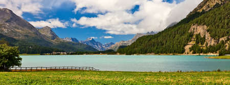 Lakeside view in alpine scenery with blue sky and clouds in summer time.