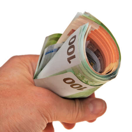 Roll of Euro banknotes hold by white male hand.の写真素材