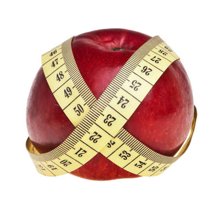 Red apple wrapped with yellow measurement tape over white background.の写真素材