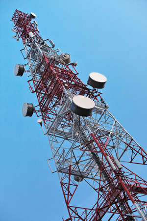 Telecommunication tower with antennas over a blue sky.の写真素材