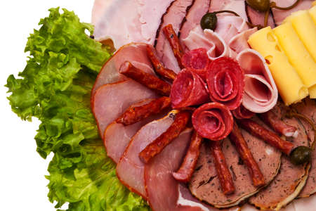 Dish closeup with salami rolls, ham, bacon, pate, cheese and lettuce.の写真素材