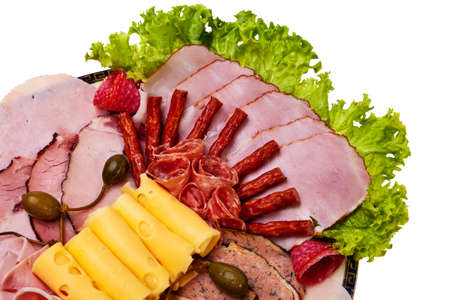 Dish with sliced ham, cheese, salami rolls, bacon and lettuce closeup view.の写真素材