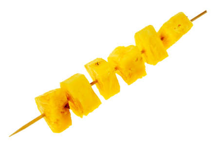 Fresh, raw pineapple chunks nailed on wooden stick isolated over white background.の写真素材
