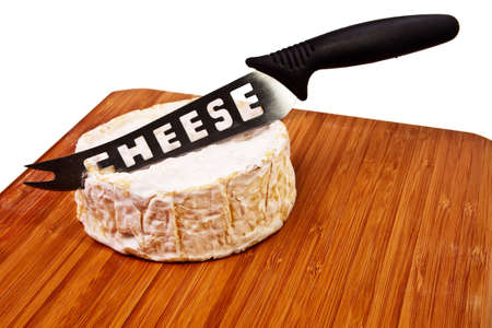 Round camembert block on wooden board with cheese knife.の写真素材