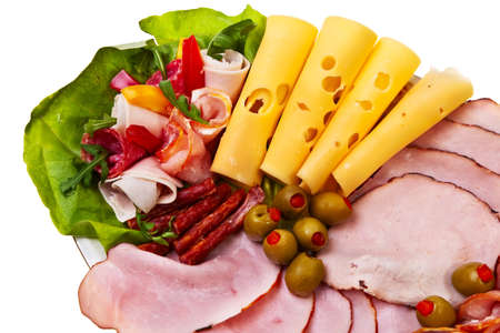 Dish with sliced smoked ham, salami rolls and cheese over white background.の写真素材