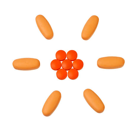 Orange pills in circular pattern isolated over white background.の写真素材