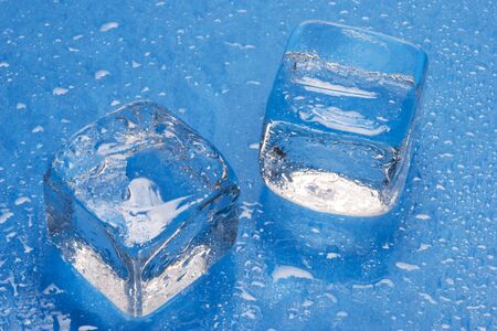 ice cubes on blue background with water dropsの写真素材