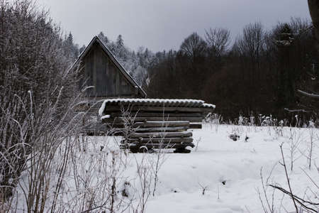 wooden hut covered with snow in the mountainsの写真素材