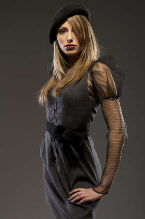 elegant fashionable blondie woman in a hat posing on grey backgroundの写真素材