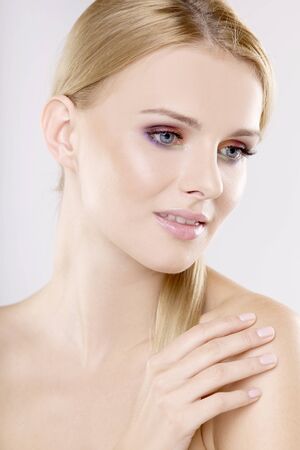 Young pretty woman with beautiful blond hairs and multicolor makeup isolated on white backgroundの写真素材