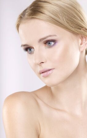 Young pretty woman with beautiful blond hairs and multicolor makeup isolated on white backgroundの写真素材