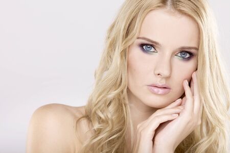 Young pretty woman with beautiful blond hairs and multicolor makeup isolated on white backgroundの写真素材