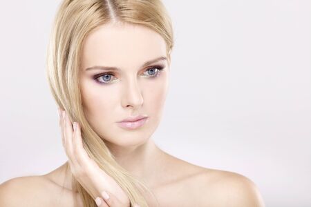 Young pretty woman with beautiful blond hairs and multicolor makeup isolated on white backgroundの写真素材