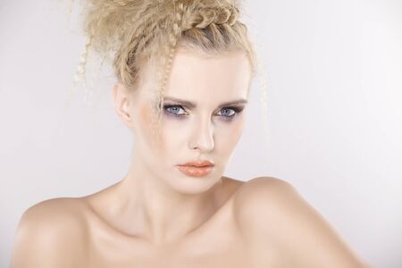 Young pretty woman with beautiful blond hairs and multicolor makeup isolated on white backgroundの写真素材