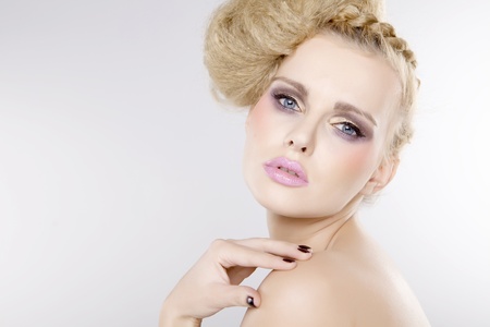 Young pretty woman with beautiful blond hairs and multicolor makeup isolated on white backgroundの写真素材
