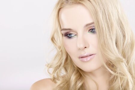 Young pretty woman with beautiful blond hairs and multicolor makeup isolated on white backgroundの写真素材