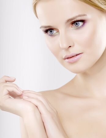Young pretty woman with beautiful blond hairs and multicolor makeup isolated on white backgroundの写真素材