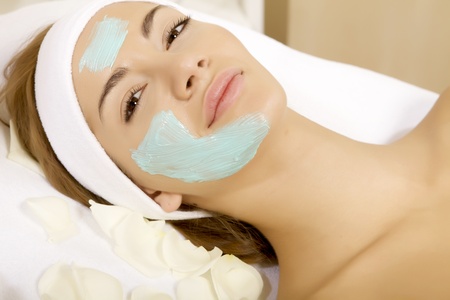 young woman getting beauty skin mask treatment on her face with brushの写真素材