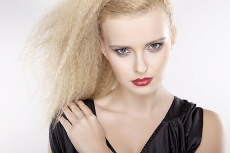 Young pretty woman with beautiful blond hairs and multicolor makeup isolated on white backgroundの写真素材
