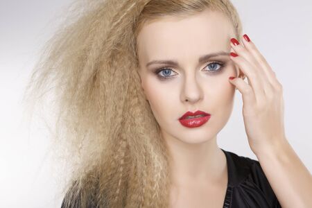 Young pretty woman with beautiful blond hairs and multicolor makeup isolated on white backgroundの写真素材