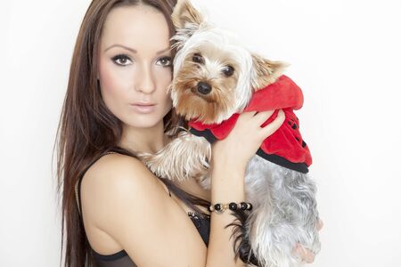 Beautiful young brunette girl with cute yorkshire terrier dog, isolated on white.の写真素材
