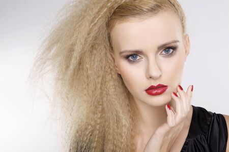 Young pretty woman with beautiful blond hairs and multicolor makeup isolated on white backgroundの写真素材