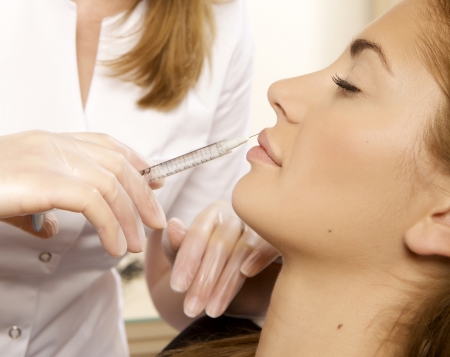 young beautiful woman having an injection mesotherapyの写真素材