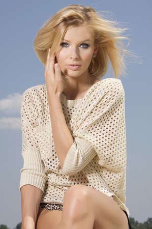 portrait of beautiful blonde girl on background blue skyの写真素材