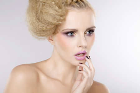 Young pretty woman with beautiful blond hairs and multicolor makeup isolated on white backgroundの写真素材