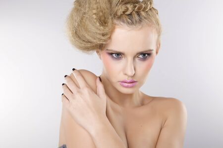 Young pretty woman with beautiful blond hairs and multicolor makeup isolated on white backgroundの写真素材
