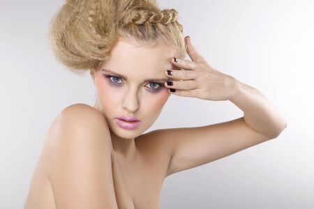 Young pretty woman with beautiful blond hairs and multicolor makeup isolated on white backgroundの写真素材