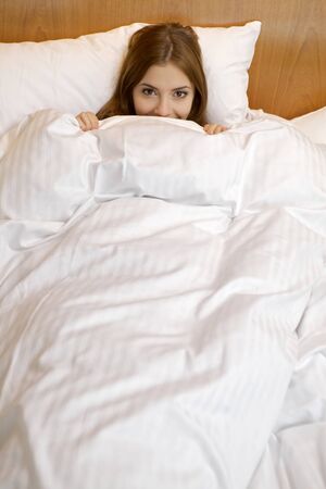 beautiful brunette woman in bedの写真素材