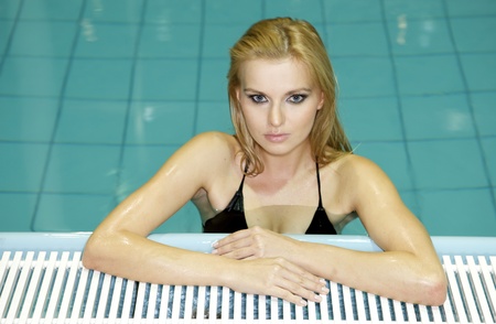 Portrait of a beautiful and attractive young woman standing in a swimming pool. の写真素材