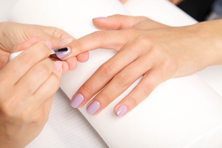 Manicure - Beautiful manicured woman's nails with violetnail polish on soft white towel.の写真素材