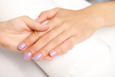 Manicure - Beautiful manicured woman's nails with violetnail polish on soft white towel.の写真素材