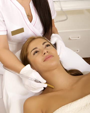 Young brunette woman receiving laser therapy. Spa studio shotの写真素材