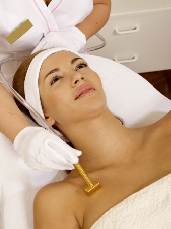 Young brunette woman receiving laser therapy. Spa studio shotの写真素材