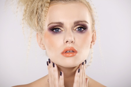 Young pretty woman with beautiful blond hairs and multicolor makeup isolated on white backgroundの写真素材