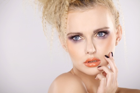 Young pretty woman with beautiful blond hairs and multicolor makeup isolated on white backgroundの写真素材