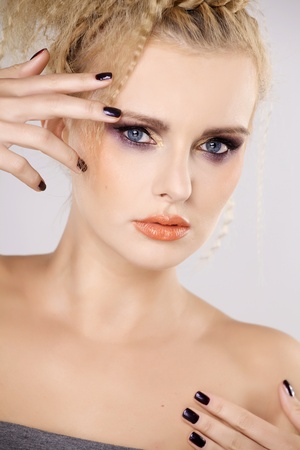 Young pretty woman with beautiful blond hairs and multicolor makeup isolated on white backgroundの写真素材