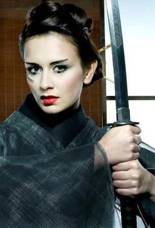 beautiful japanese grey kimono woman with samurai sword in traditional roomの写真素材