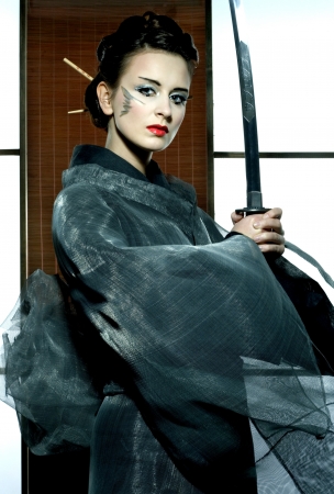 beautiful japanese grey kimono woman with samurai sword in traditional roomの写真素材