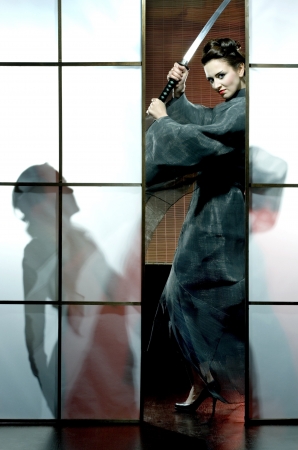 beautiful japanese grey kimono woman with samurai sword in traditional roomの写真素材