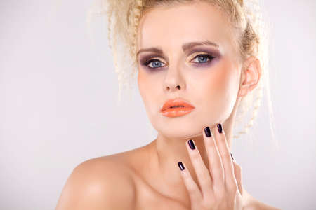 Young pretty woman with beautiful blond hairs and multicolor makeup isolated on white backgroundの写真素材