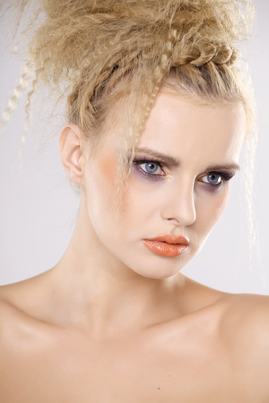 Young pretty woman with beautiful blond hairs and multicolor makeup isolated on white backgroundの写真素材